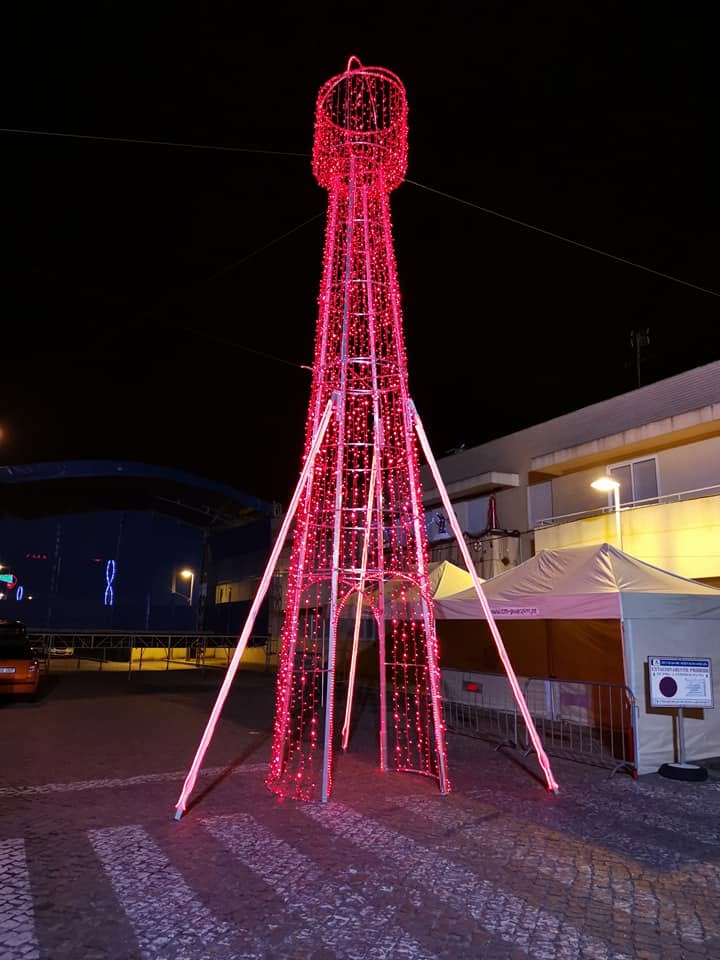 Torre de luz em LED vermelho montada num largo durante uma festa popular